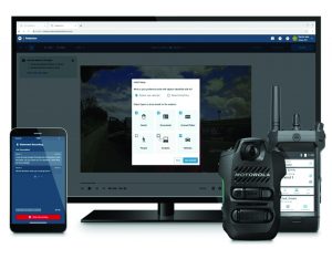 Monitor shows video analysis setup with detection options; Motorola body cam, handheld device, and smartphone with statement screen in foreground