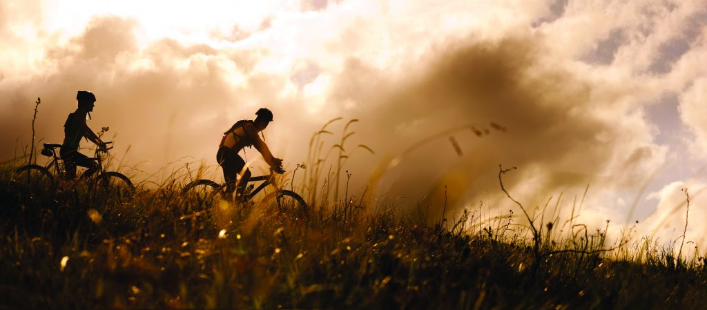 Happy couple riding bicycles outside, healthy lifestyle fun concept