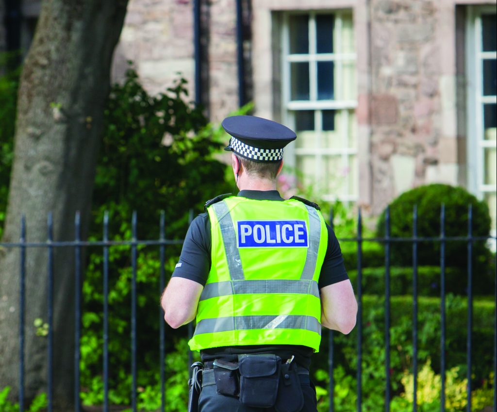 EDINBURGH, SCOTLAND - JULY 21: Police officer on guard duty near the Royal palace. EDINBURGH, SCOTLAND - JULY 21