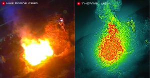 A police officer monitors a live drone feed on a computer screen showing thermal view