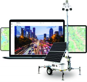 Mobile surveillance unit with solar panels and cameras sits before laptop showing city traffic; two tablets on sides display detailed maps.