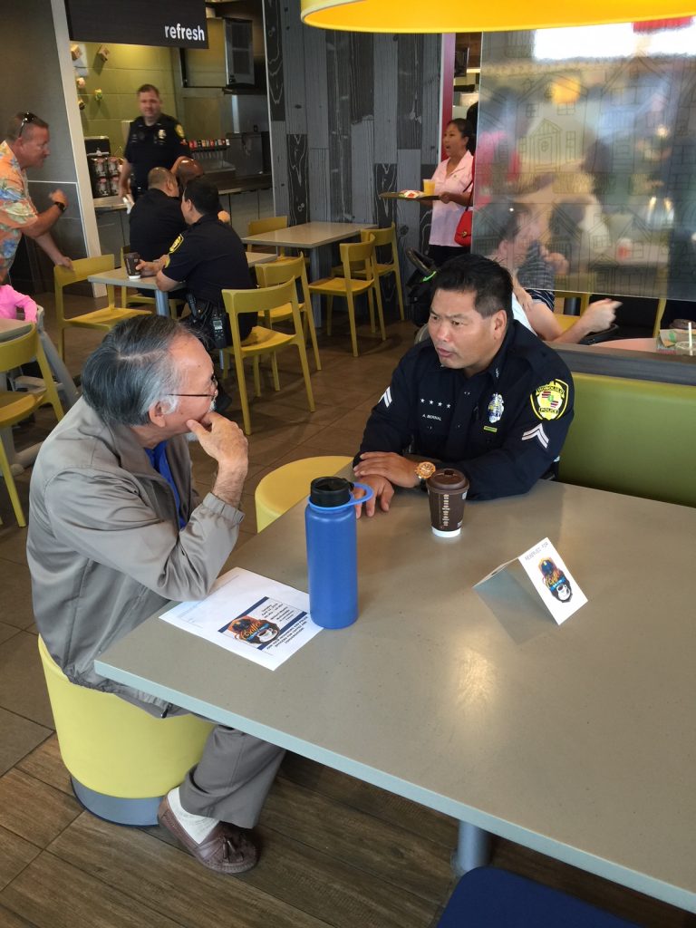 Hawthore officer converses with an older community member over coffee.