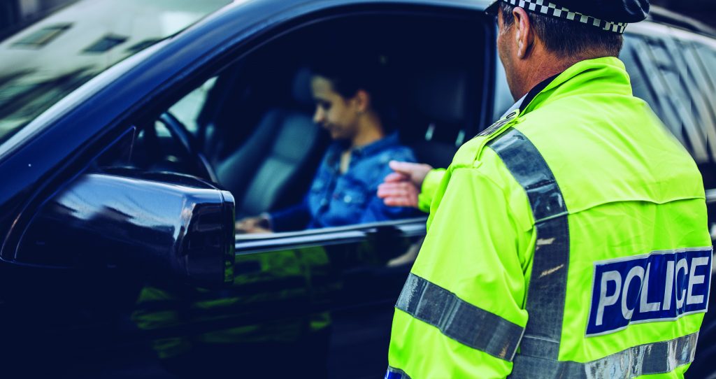 Man and woman, police officer making a traffic stop on the street.