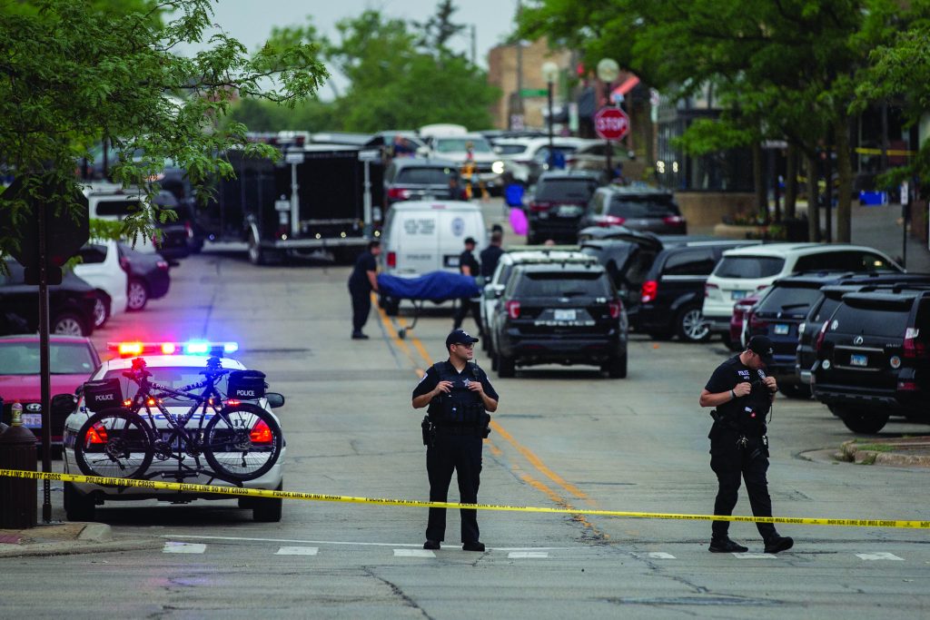 HIGHLAND PARK, IL - JULY 04: First responders take away victims from the scene of a mass shooting at a Fourth of July parade on July 4, 2022 in Highland Park, Illinois. At least six people were killed and 19 injured, according to published reports.