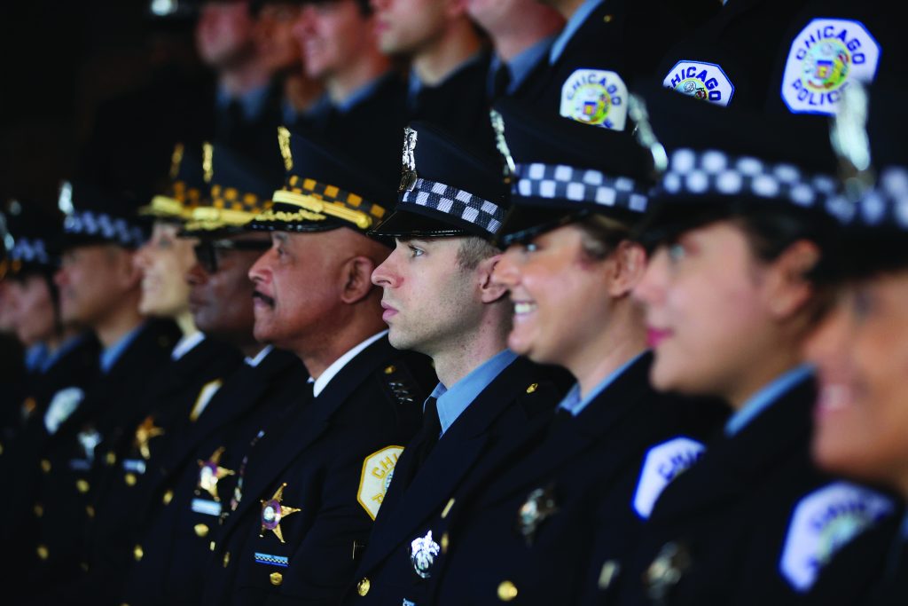 CHICAGO, ILLINOIS - OCTOBER 20: Chicago police officers pose for pictures at a Chicago Police Department promotion and graduation ceremony on October 20, 2021 in Chicago, Illinois. The city of Chicago has started to place police officers on unpaid leave for refusing to comply with the city's requirements that they report their COVID-19 vaccination status. Only about 65 percent of the city's police have complied with the order.
