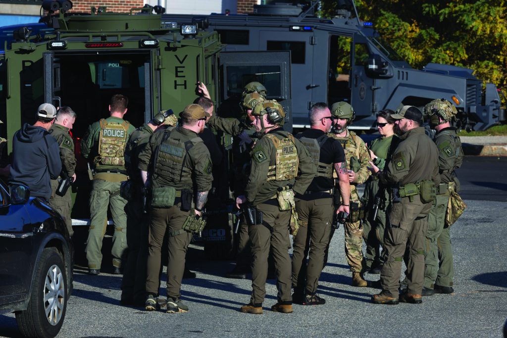 LEWISTON, MAINE - OCTOBER 27: Law enforcement officials gather at the Lewiston High School as they continue a manhunt for suspect Robert Card following a mass shooting on October 27, 2023 in Lewiston, Maine. Police are actively searching for a suspect, Army reservist Robert Card, who allegedly killed 18 people in a mass shooting at a bowling alley and restaurant in Lewiston, Maine.