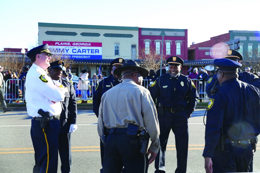 Police officers stand by while awaiting the funeral motorcade of former President Jimmy Carter