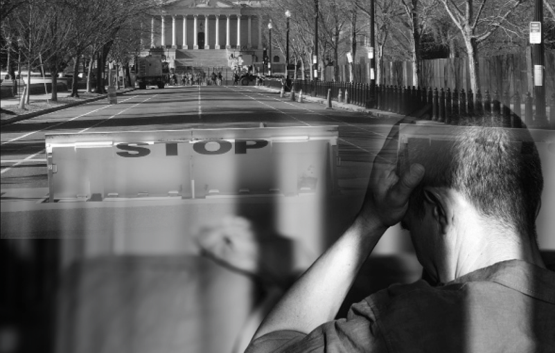 Black‑and‑white composite image shows the U.S. Capitol at the end of an empty street blocked by a STOP barricade, overlaid with a seated figure seen from behind holding one hand to the head