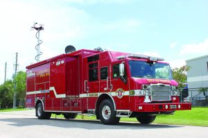 Red 'City of Tampa' fire truck labeled 'Special Operations' parked outdoors; equipped with tools, compartments, and raised antenna.