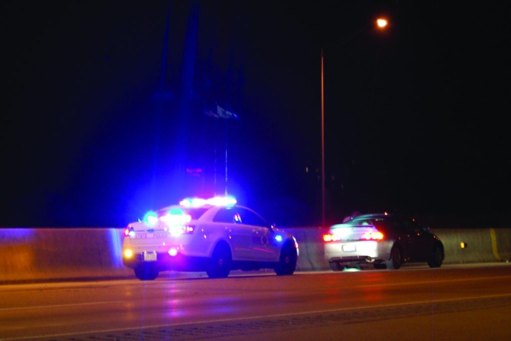 Officer pulling someone over on the side of the highway
