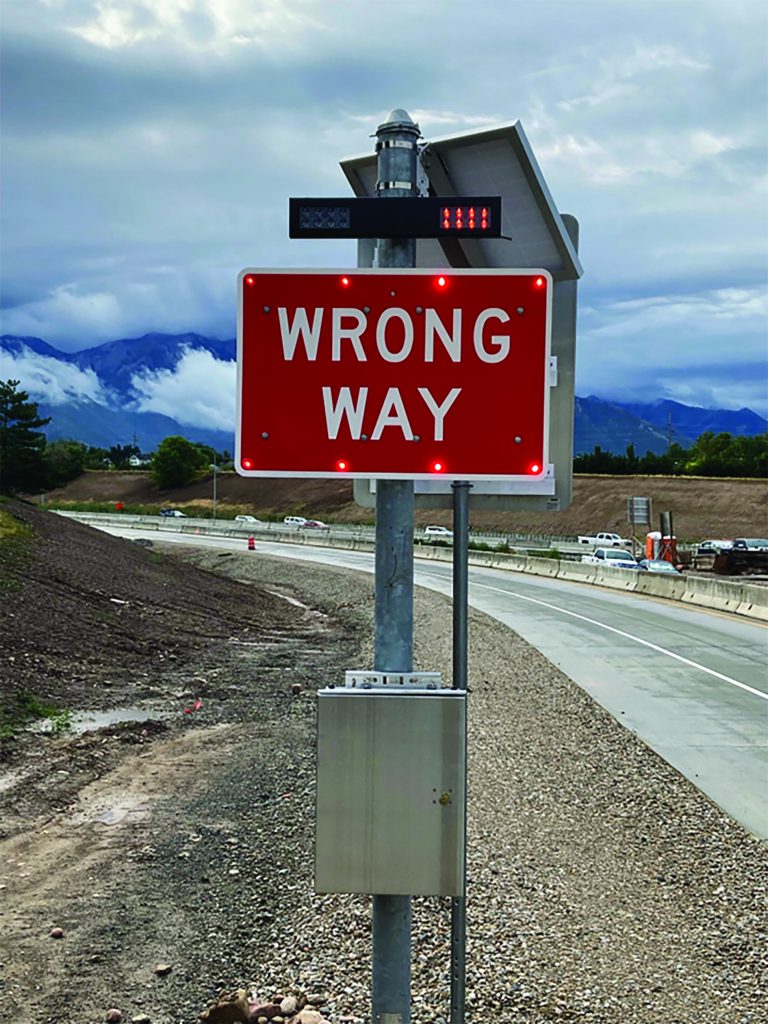 Wrong way sign with a flashing red light above it