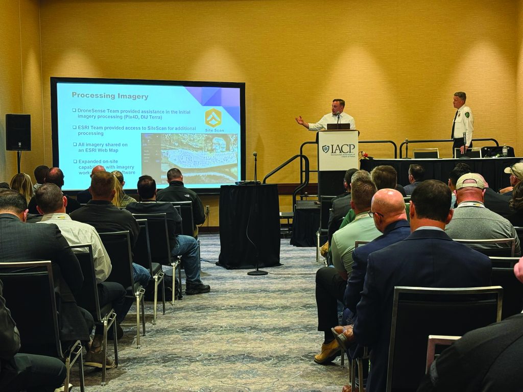 Law enforcement professionals seated in conference room facing IACP podium; speaker presents slides on 'Processing Imagery' during formal session