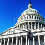 The dome of the United States Capitol against a deep blue sky in Washington, DC.