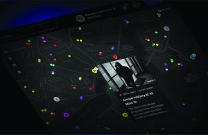 Dark map interface with multicolored incident markers and a pop‑up showing surveillance of a hooded suspect linked to an armed robbery location on Main Street