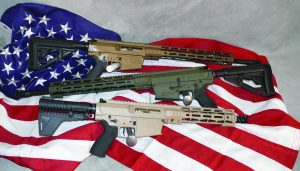 Three rifles with tan and olive finishes are displayed atop a folded U.S. flag, showing adjustable stocks, extended handguards, muzzle devices, pistol grips, receiver controls, and metallic bolt components against a neutral backdrop
