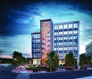 Modern building with 'American Physical Therapy Association' and 'IACP' sign, glass facade, geometric design; trees, streetlights, and evening sky in view.