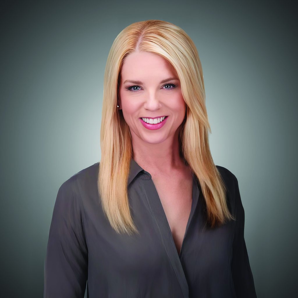 Person with long, straight blonde hair in dark gray button-up shirt, posed against a gradient gray background