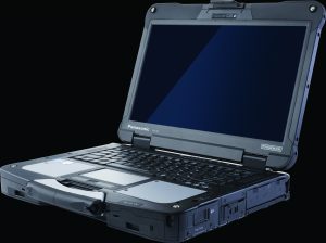 Rugged Panasonic Toughbook laptop shown open, featuring reinforced casing, thick hinges, full keyboard, touchpad, ports, and blank screen on dark background
