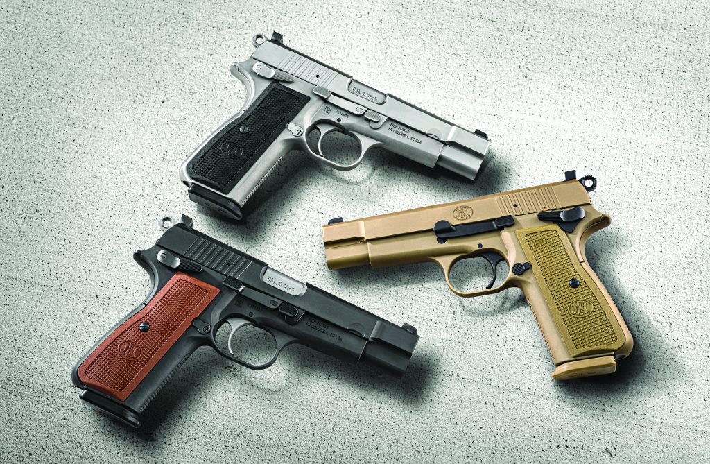 Three semi-automatic pistols on textured gray surface; finishes include silver with black grip, black with brown grip, and tan with matching grip