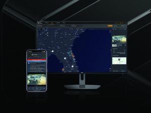Smartphone shows car alert; monitor displays law enforcement app with map and incident markers, highlighting digital tools for field response
