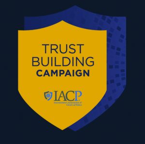 Yellow shield graphic on dark background with text ‘Trust Building Campaign’ and IACP logo for International Association of Chiefs of Police